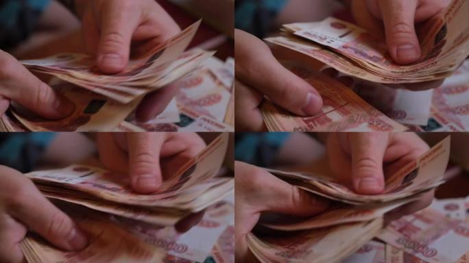 男性手数俄罗斯的钱5000钞票的背景旋转一堆钱