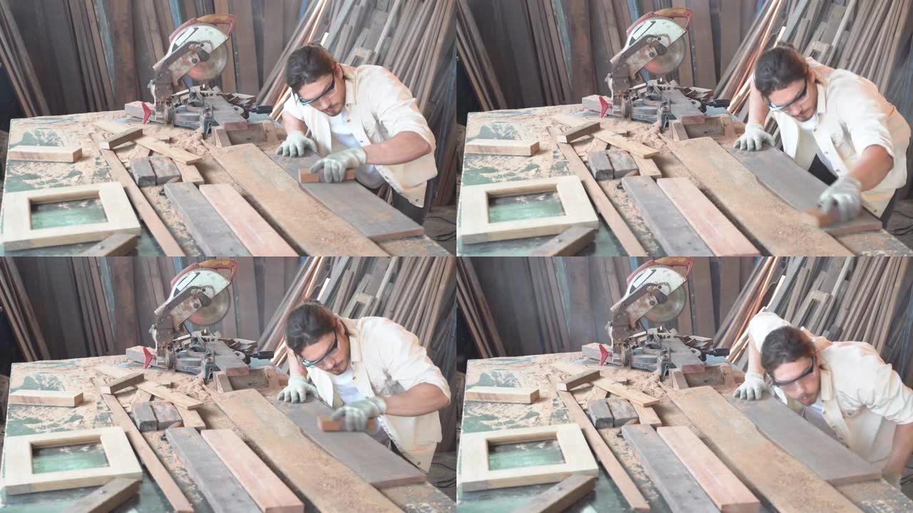木匠在车间工作。他正在锯一块木板。