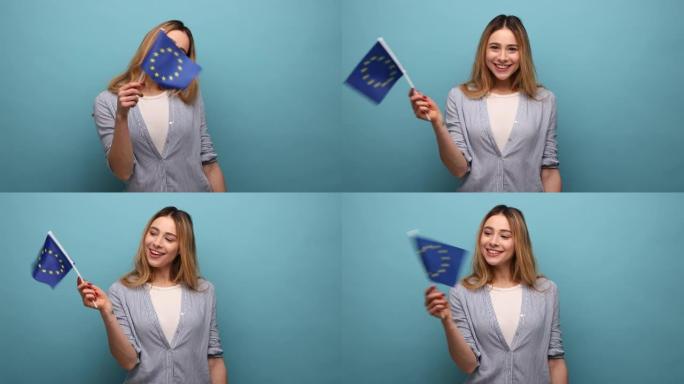 迷人的卷发女子，手里拿着欧盟国旗，微笑着看着镜头。