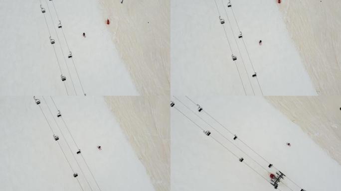 单人滑雪者在滑雪缆车下沿着滑雪坡走下的俯视图