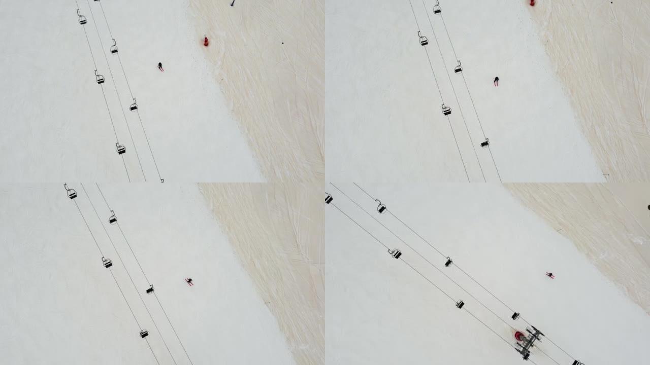 单人滑雪者在滑雪缆车下沿着滑雪坡走下的俯视图