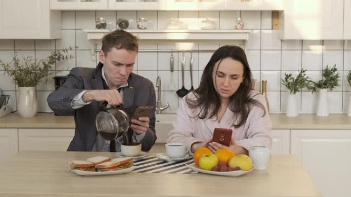 夫妇在使用智能手机时喝咖啡
