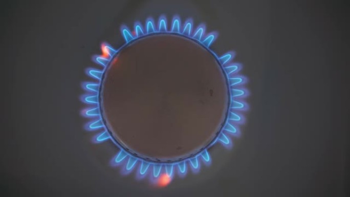 家庭炉灶起火的特写镜头。带有燃烧的丙烷火焰的煤气炉。产业资源与经济的概念