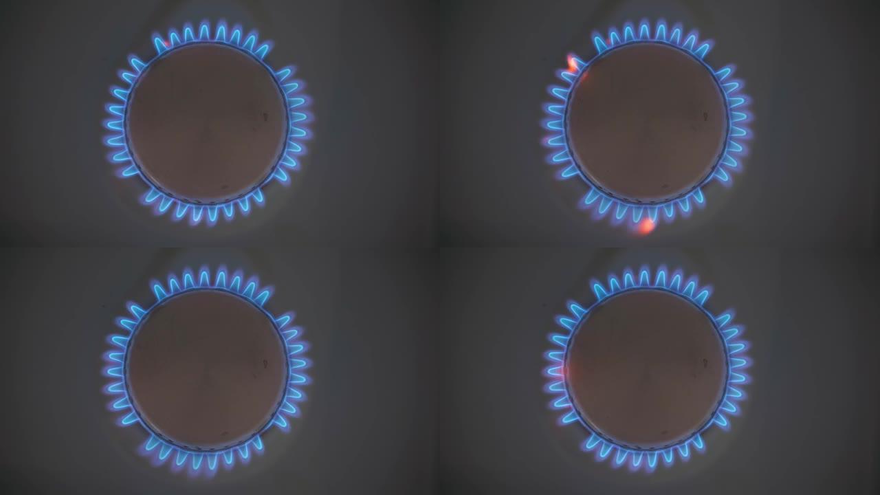 家庭炉灶起火的特写镜头。带有燃烧的丙烷火焰的煤气炉。产业资源与经济的概念