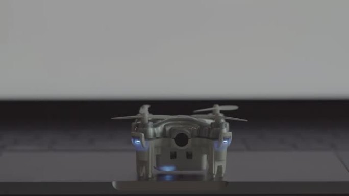 未来的交通概念。微型无人机从带有灯光的笔记本电脑上起飞