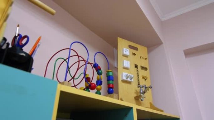 幼儿园游戏室架子上的珠子迷宫和繁忙的木板