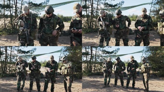 四名男子站在守卫士兵穿着摩洛制服，军队准备保卫领土，他们检查武器，开锁，短手枪，长枪，藏在口袋上的腰