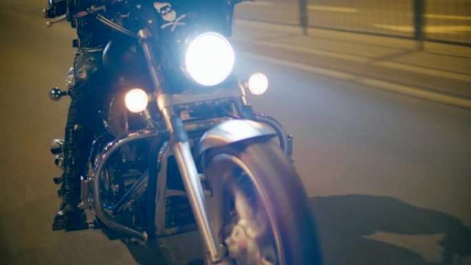 接近凉爽的摩托车细节，车轮和灯光在夜间快速行驶