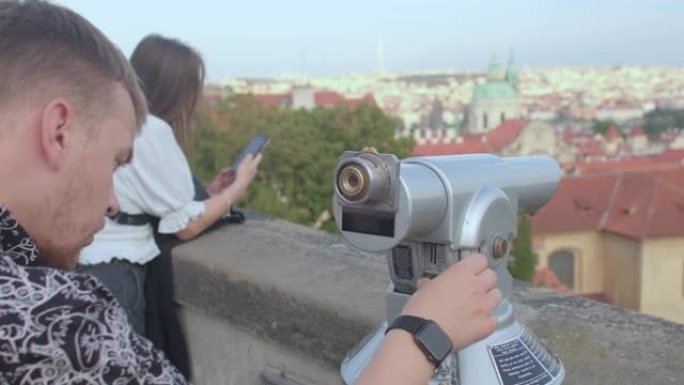 用旅游望远镜观察城市。布拉格。