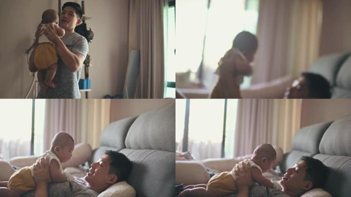 亚洲华裔父亲早上从床上抱起男婴与他玩耍