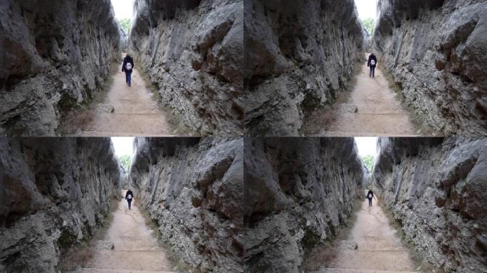 女人在昆卡市恩坎塔达自然公园的垂直岩壁之间行走。