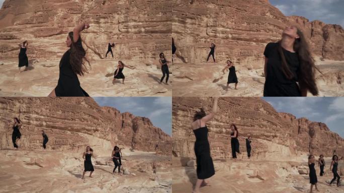 身着黑衣的美女们在沙漠峡谷中表演着狂喜的舞蹈