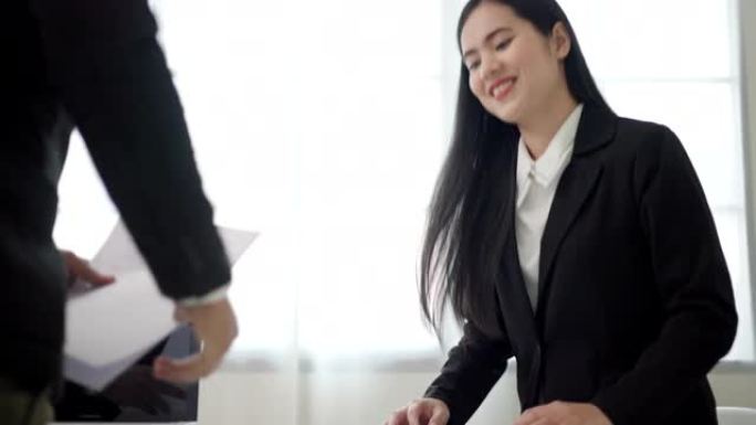 聪明的亚洲女人在求职面试前握手问候人力资源人员。快乐的女寻求者或保险经纪人提出商业交易。女商人发送简