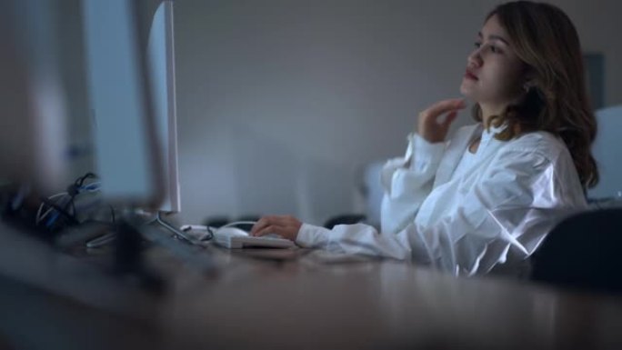 疲惫的过度工作的亚洲女性员工坐在现代办公室的工作场所办公桌前，用笔记本电脑处理截止日期任务，紧急项目