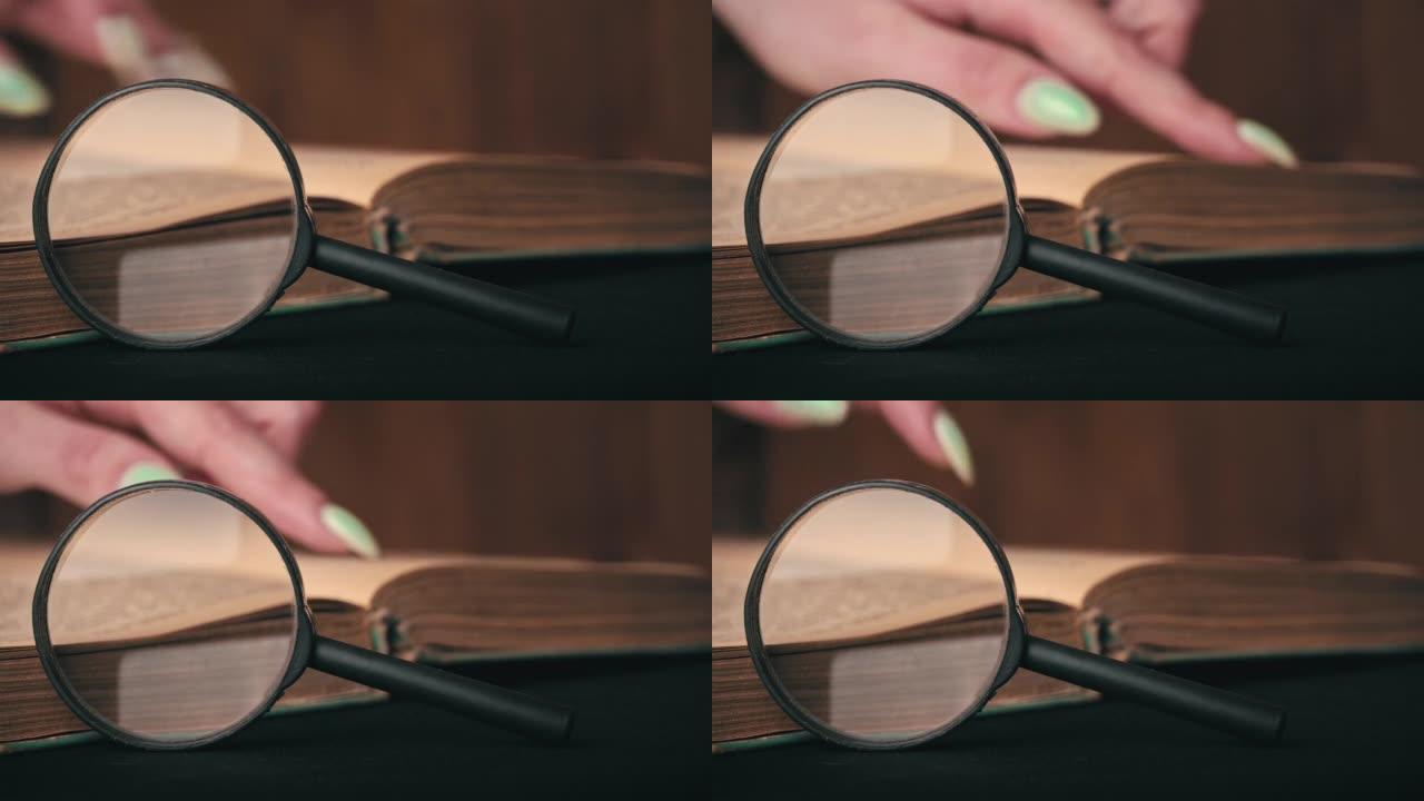 女孩在放大镜旁边翻着一本旧书的一页