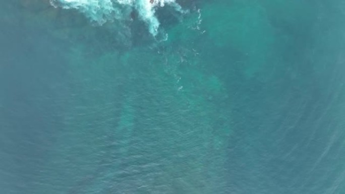 海浪撞击海洋中的岩石。一幅和平的自然画卷。水中岩石的鸟瞰图。海洋和陆地的交汇点。慢动作120 fps