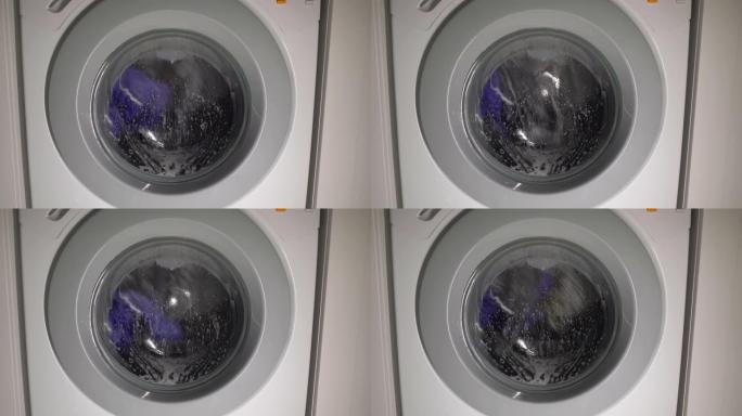 洗衣机洗衣服。洗衣机滚筒正在旋转