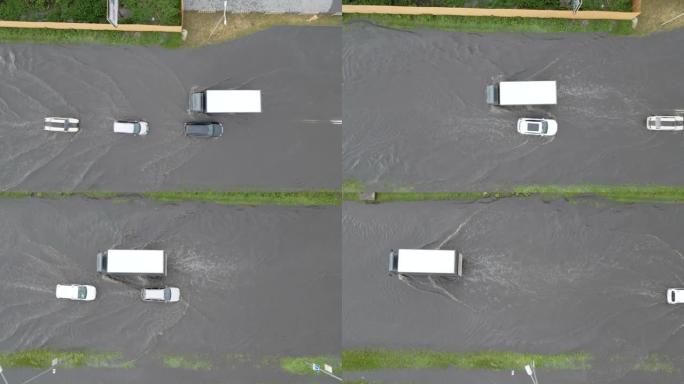 大雨过后，汽车在洪水泛滥的街道上行驶的城市交通鸟瞰图。道路排水系统存在问题。