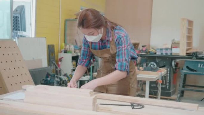 用铅笔和尺子用木板工作的女木匠