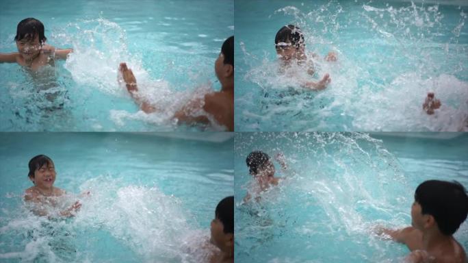 夏天，年轻的亚洲男孩兄弟在游泳池里享受和玩水的慢动作镜头