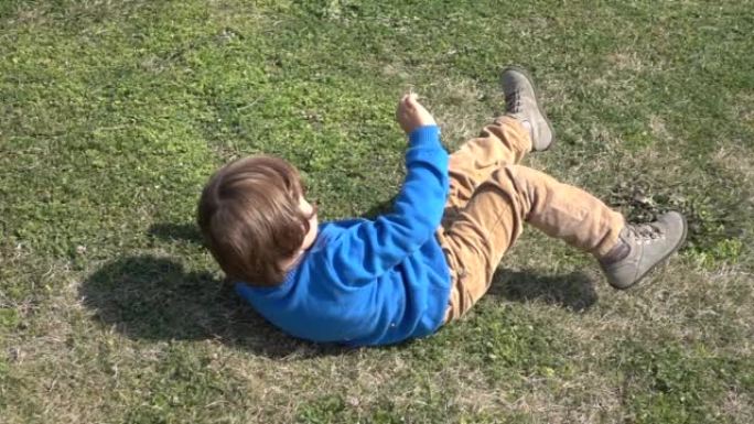 高清视频男孩在绿色的草地上滚动