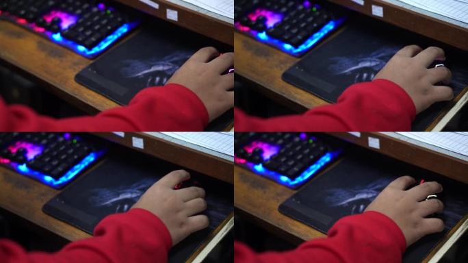 穿着红色连衣裙的男孩用台式电脑玩游戏娱乐。