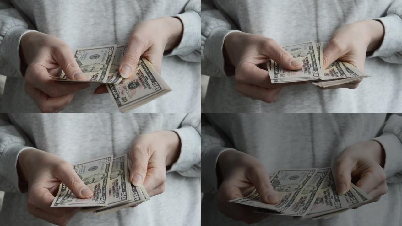 一个女人用手数钞。美国的钱，美元。