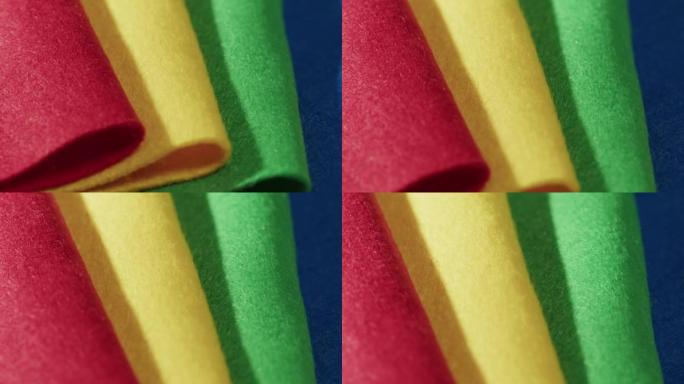 柔软的彩色毛毡，红色，黄色，绿色和蓝色材料。毛毡织物表面纹理抽象背景不同颜色