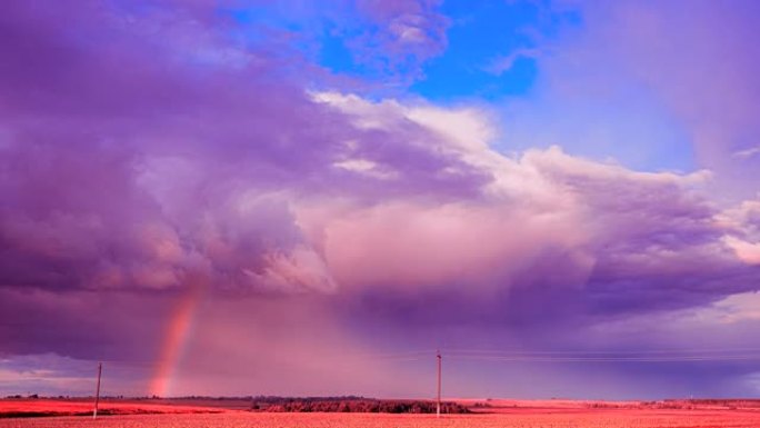 雨中色调天鹅绒紫罗兰紫红色天空，乡村景观田野上方地平线上有彩虹。农业和天气预报概念。延时，延时，延时