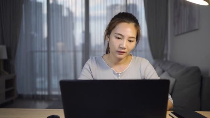 亚洲妇女在深夜工作时压力很大，在家庭办公室的笔记本电脑或笔记本电脑上存在项目研究问题。