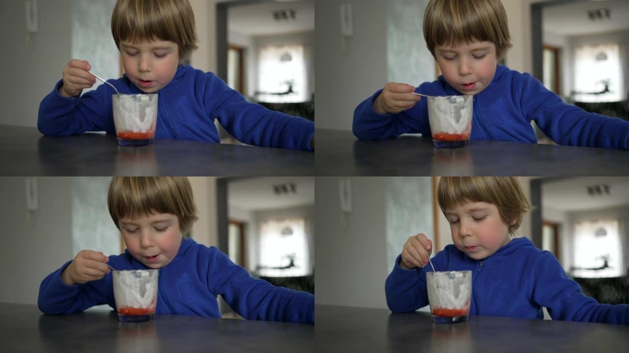 正在吃草莓和奶油的蹒跚学步的男孩
