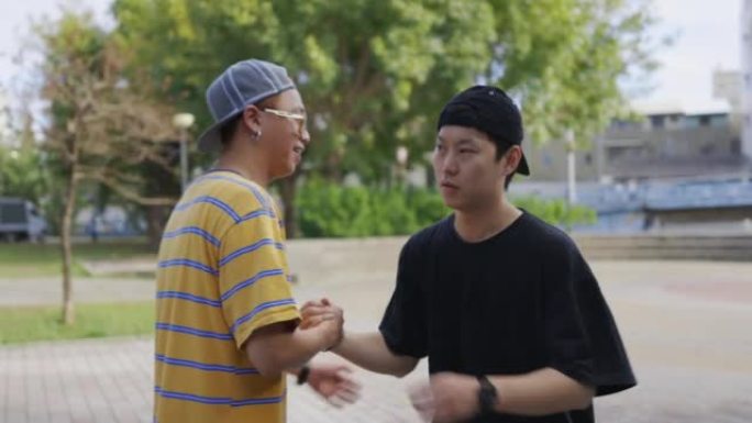两个年轻的亚洲男子在街上打招呼