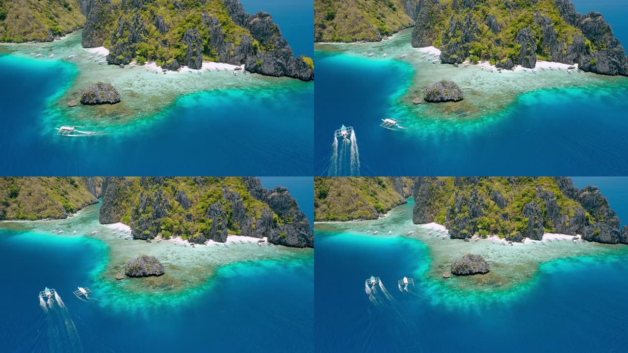 旅游banca船接近菲律宾巴拉望爱妮岛清水岛海滩的空中无人机镜头。岛前的岩石和清澈的浅绿松石泻湖水