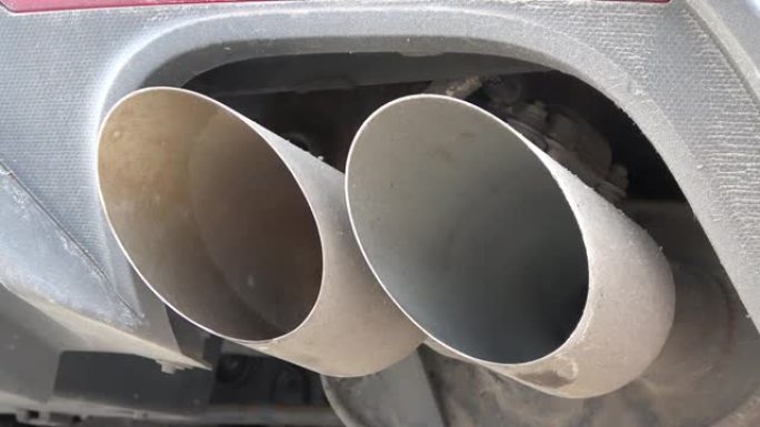 发动机运转的跑车脏双排气管。