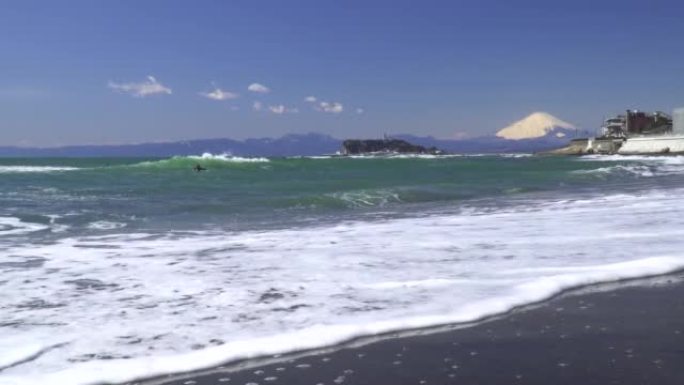 海浪拍打着海滩、江之岛和富士山。