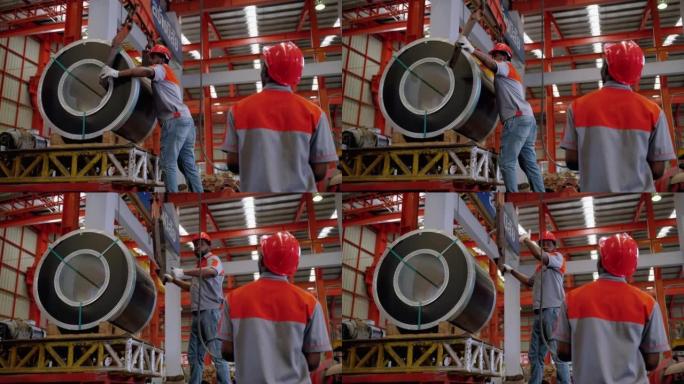 非裔美国人的工人正在使用提升机和起重机来提升钢铁或要在工厂中分类的货物。