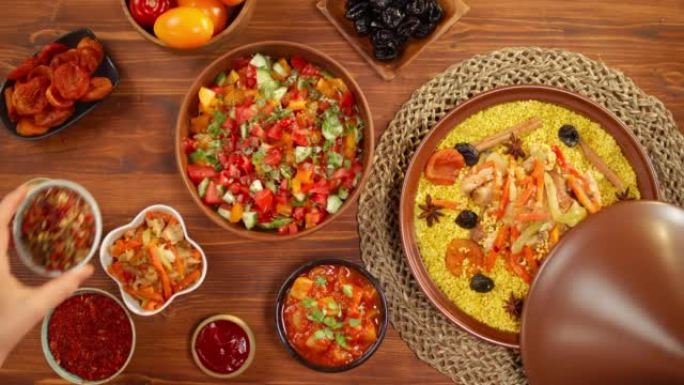摩洛哥美食顶视图。Tajine，由羊肉和茄子制成的传统菜肴，蔬菜沙拉。中东文化。蒸粗麦粉配羊肉特写，