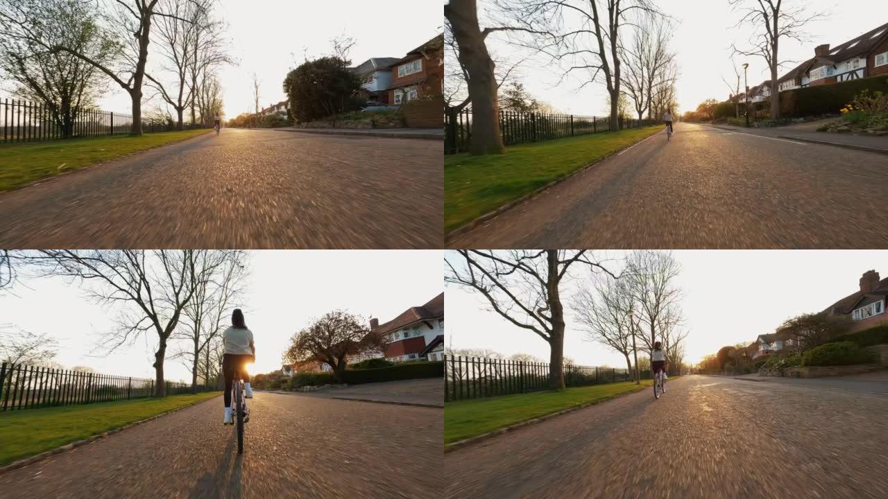 日出时，年轻女子在居民区空旷的道路上骑自行车