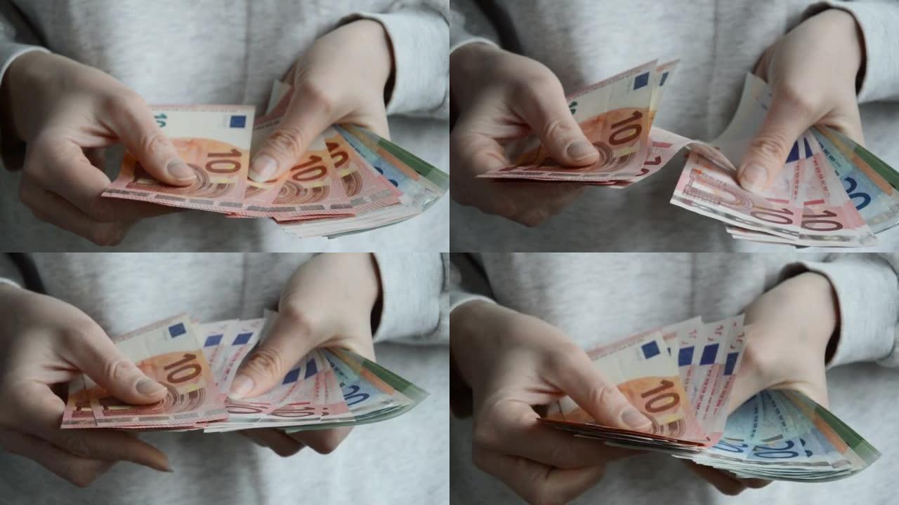 一个女人用手数钞。欧洲货币，欧元。