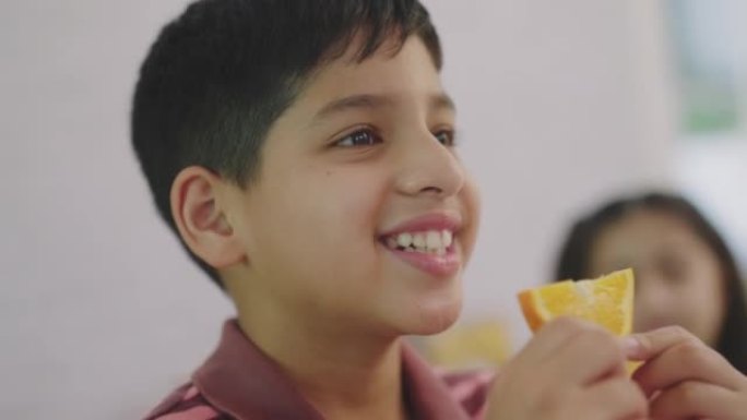 印度男孩吃他的橘子