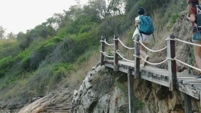 年轻的成年朋友旅行者走到俯瞰山景的平台边缘