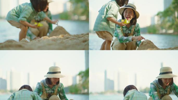 夏天，亚洲母亲和可爱的小儿子在阳光明媚的美丽海滩上一起玩沙堆。享受和快乐的新活动。假日旅行的生活方式