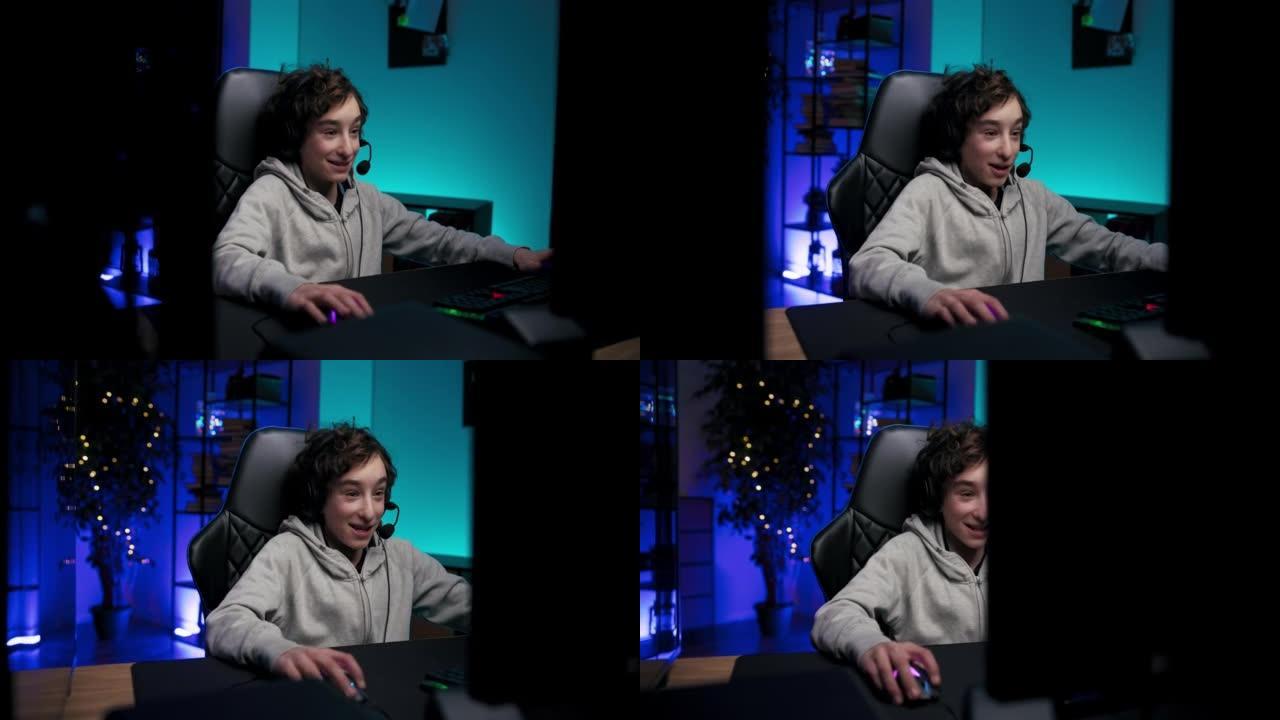被游戏迷住了，一个充满兴奋的男孩正在玩电脑游戏，看着监视器，在网上与团队成员交谈，一个带蓝色led灯