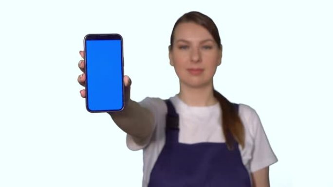 穿着蓝色工作服的女建筑商拿着蓝屏手机