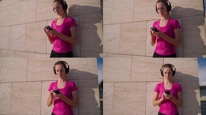 年轻女子正在通过无线耳机听音乐，在智能手机中切换歌曲