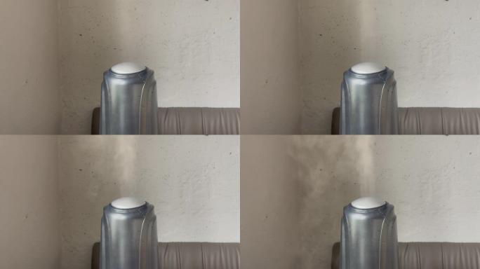 加湿器在灰色墙壁背景上从低到高功率工作。来自加湿器的水雾蒸汽。