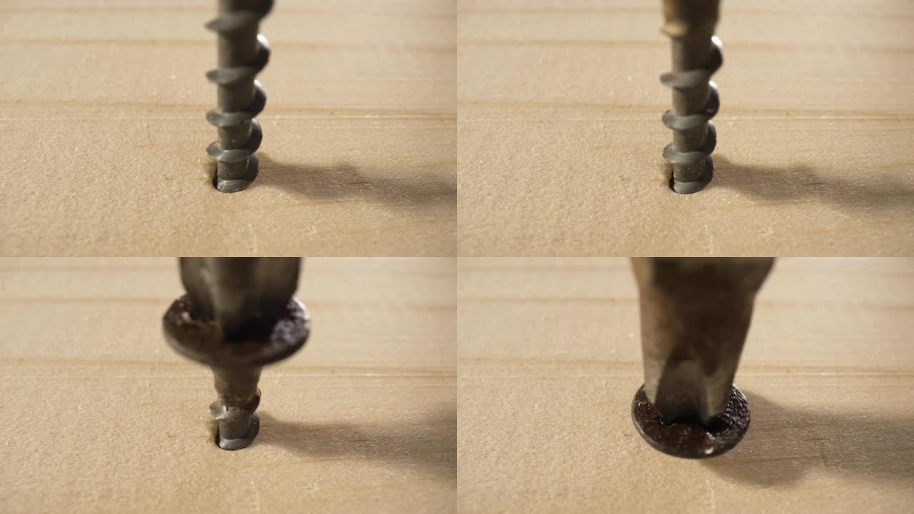螺丝枪将黑色自攻螺钉拧成木板。用螺丝拧到位的情况下，非常接近在木头上钻孔。修理工作、施工、拧紧、紧固