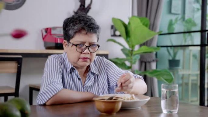 亚洲老年妇女独自吃饭，孤独，精神卫生问题