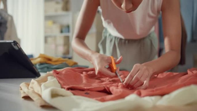 年轻的亚洲小企业主妇女准备包装订单衬衫产品发送给客户，并在家里的平板电脑上检查库存。