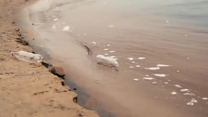 塑料垃圾，空瓶子躺在海边。塑料垃圾扔进水里就是废物。环境污染。